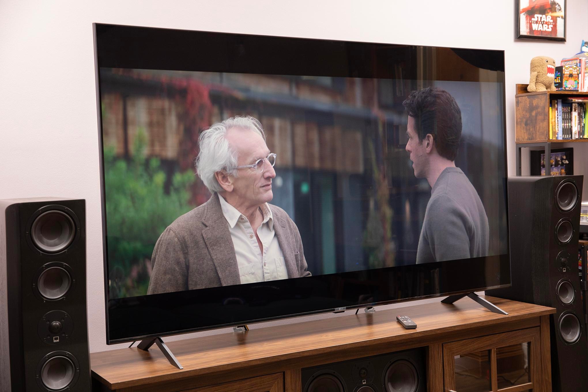 LG MRGB95B RGB LED TV on a TV stand showing a TV show.